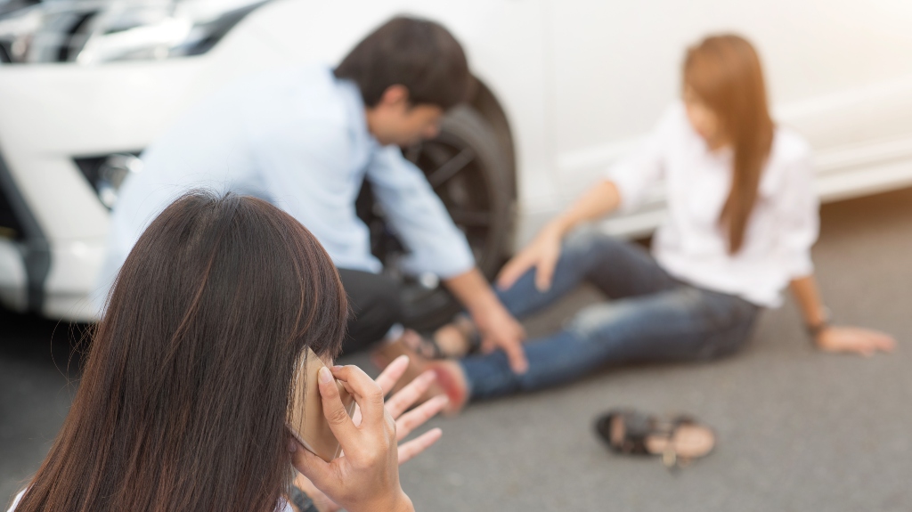 woman calls an ambulance after a car accident in which a passenger was injured