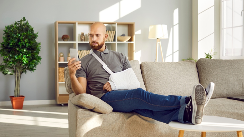 Man with broken arm using mobile phone