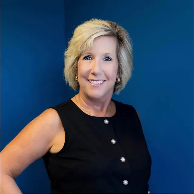 Shelly Dreyer wearing a black top, looking confidently at the camera